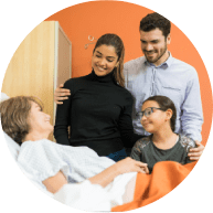 Smiling family visiting senior woman during treatment at hospital