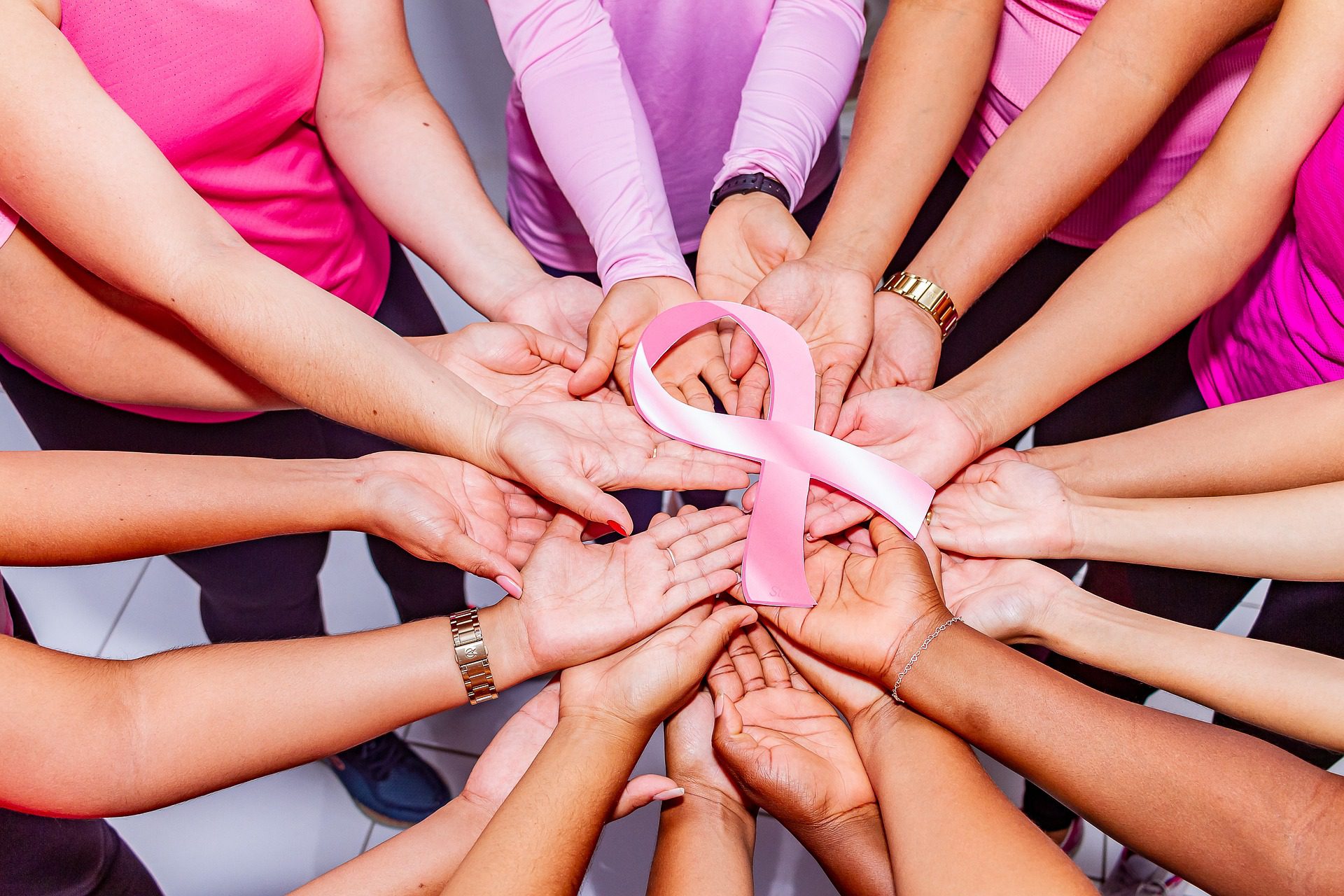 breast-cancer-6701684_1920 Hands together holding a pink ribbon for breast cancer awareness.
